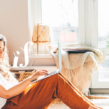 Girl sitting in her bedroom working on laptop
