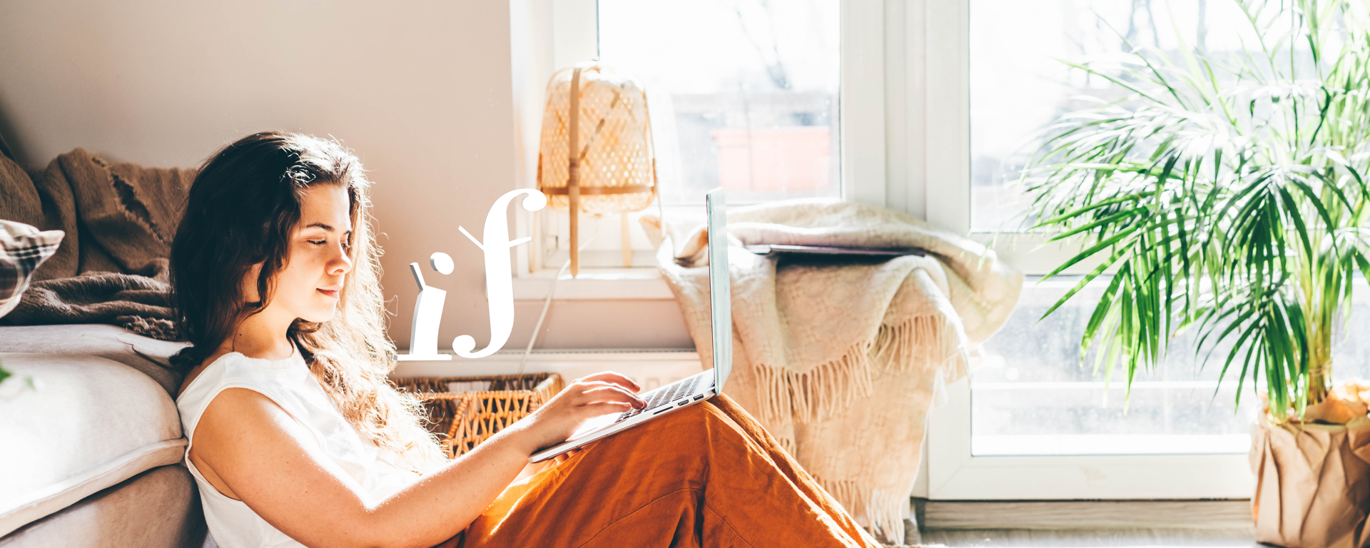 Girl sitting in her bedroom working on laptop