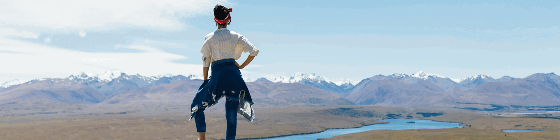 Woman looking out from a cliff top at a mountain range in New Zealand. Nationwide personal loans available at Instant Finance