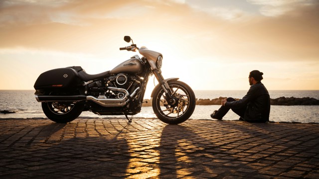 Man at sunset with his motorbike thinking about motorbike finance